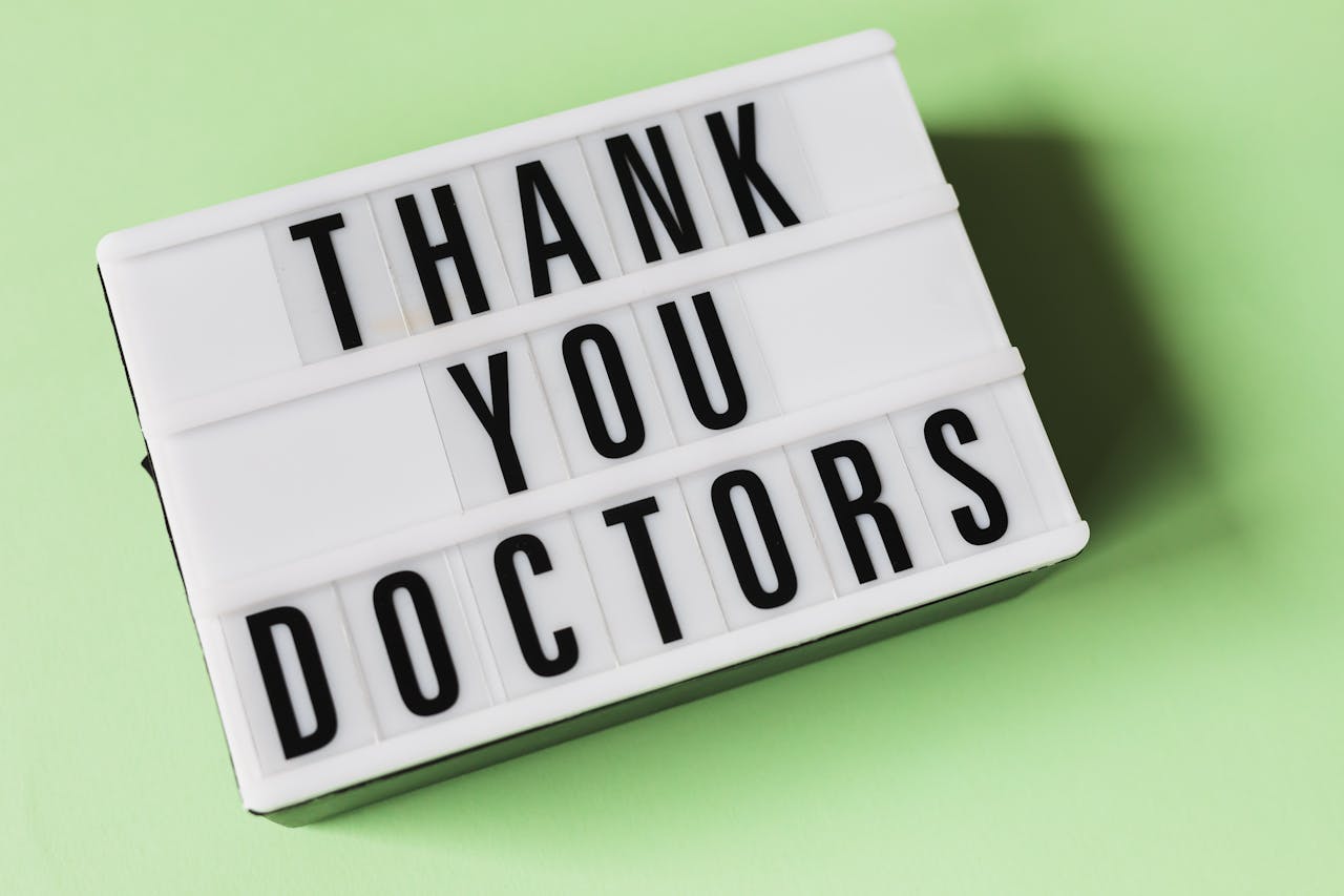 From above of vintage light box with THANK YOU DOCTORS gratitude message placed on green surface